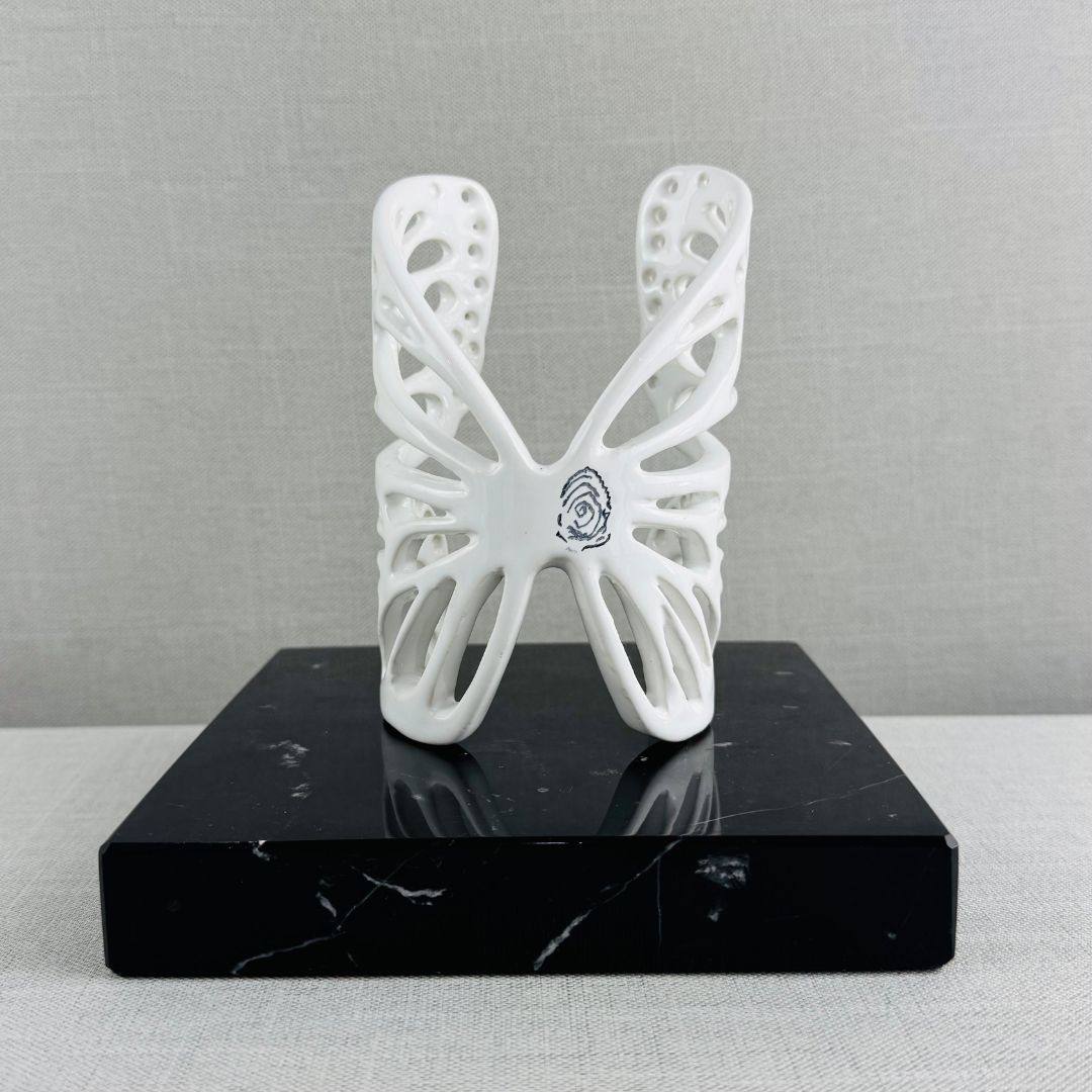Mariposa perforada con base de mármol negro.